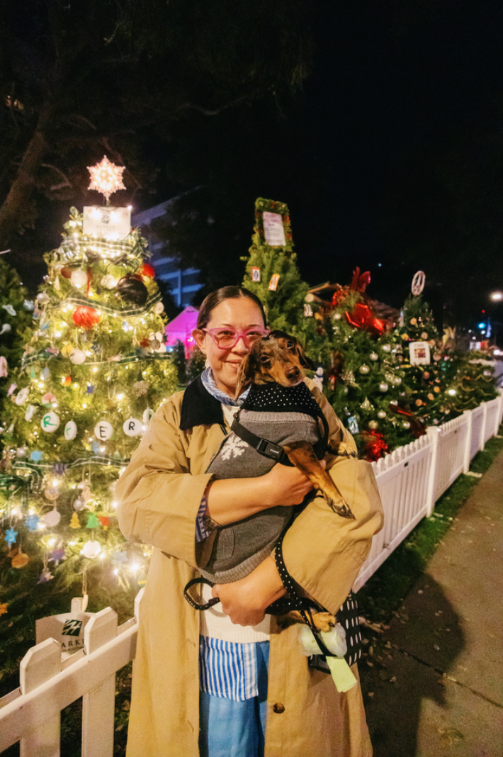 the author and her dog in front of the christmas trees 